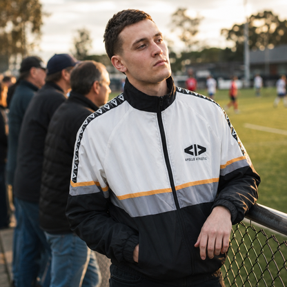 Man wearing a sports jacket with a logo on a sports field